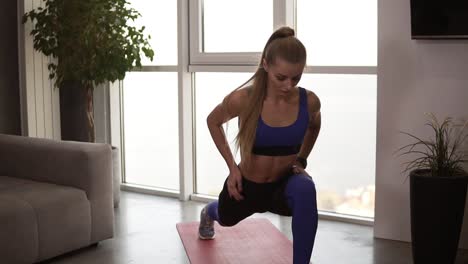 Mujer-Joven-En-Forma-Con-Ropa-Deportiva-Haciendo-Ejercicio-De-Estocada-De-Estiramiento-En-Interiores,-Interior-De-Casa.-Actividad-Y-Estilo-De-Vida-Saludable.-Vista-Frontal