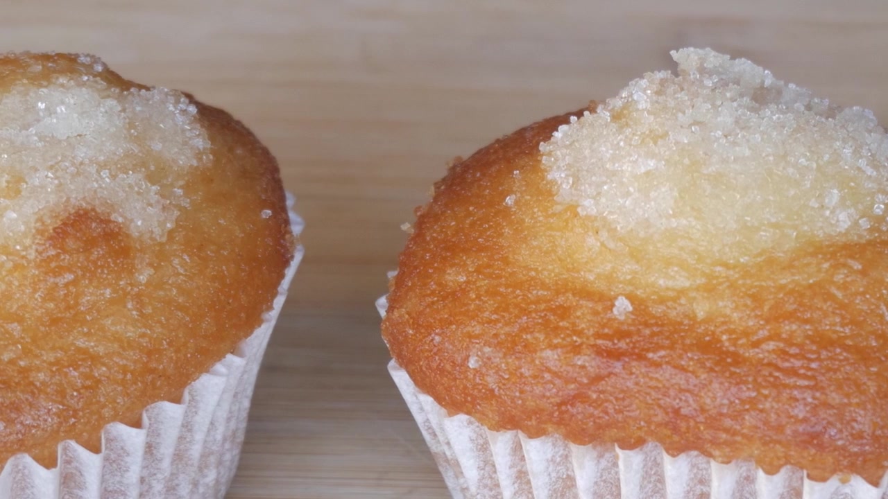 Close-up of sugar-dusted muffins on a wooden surface