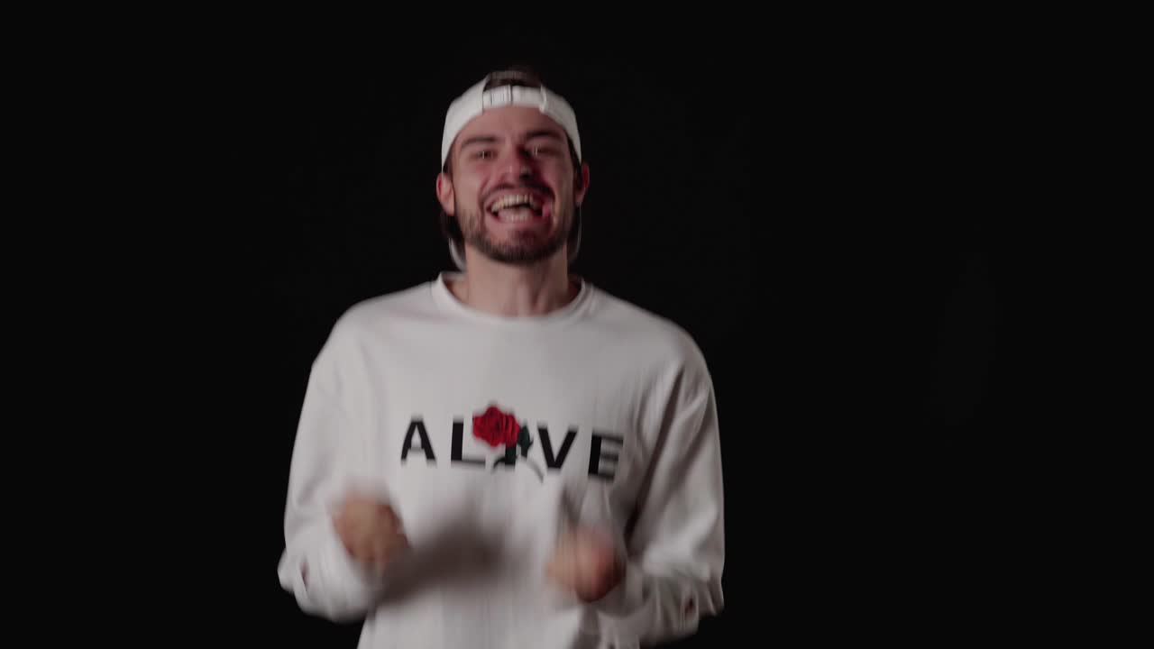 hombre moderno de 20 años emocionado, gesto alegre, fondo amplio y negro.