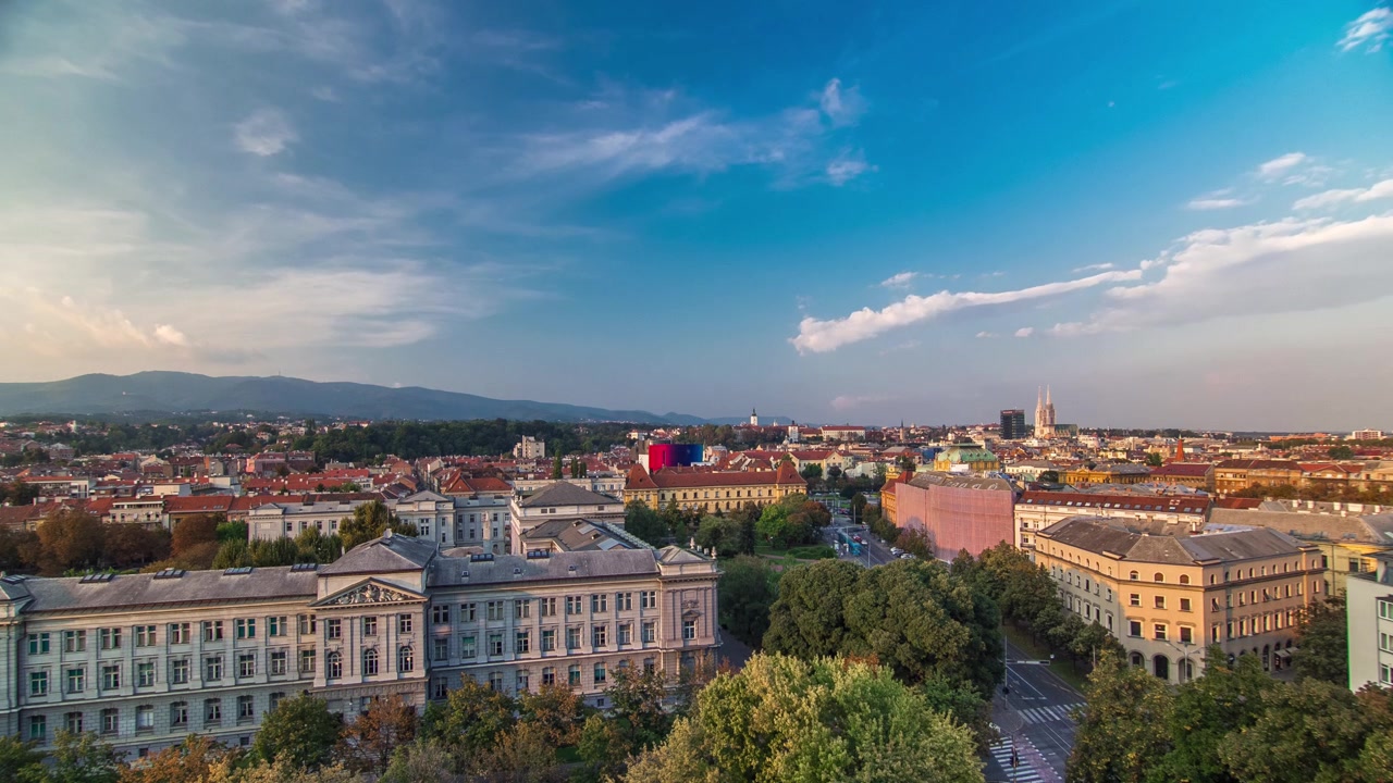 Panorama do centro da cidade timelapse filmado do topo do arranha-céu com vista para o cruzamento em frente ao teatro nacional e museu em Zagreb, Croácia. Vista antes do pôr do sol.