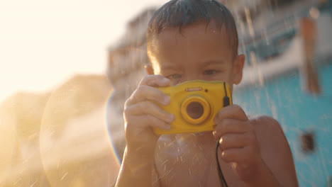 child with waterproof camera under beach shower