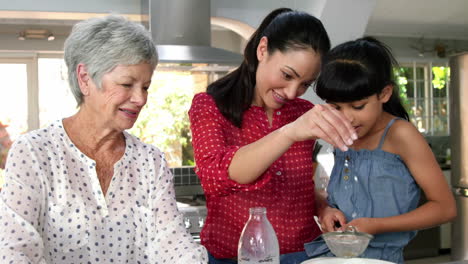 little girls, grandma and his mom preparing cake