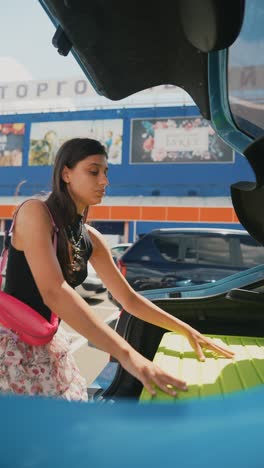 mujer cargando el maletero del coche