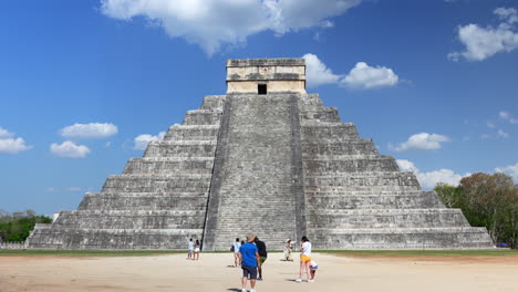 tourists sightseeing in front of mayan pyramid in chichen itza, yucatan peninsula