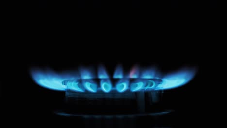 gas ignition on the burner on a dark background, close-up