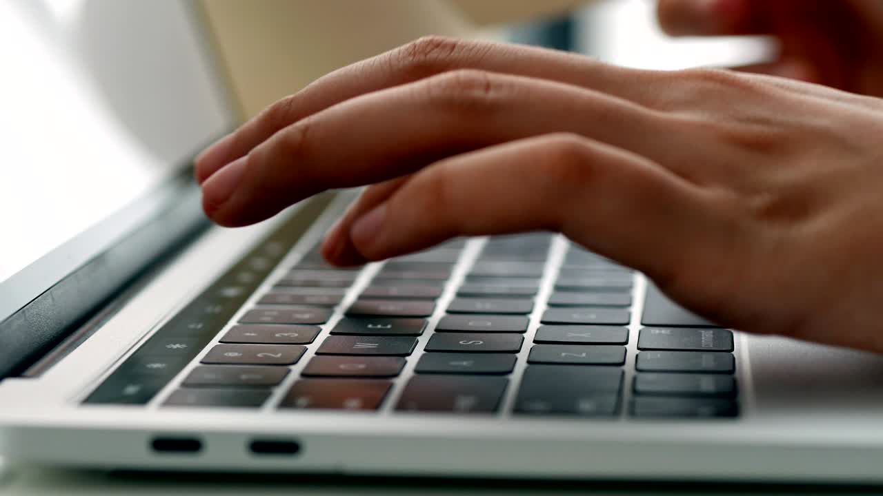 Close up hand typing on a Keyboard computer laptop at office. One young woman only using computer desktop PC.