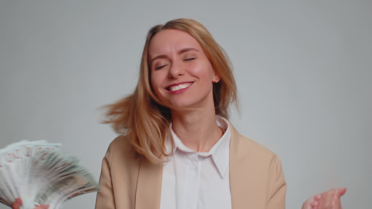 Rich pleased boss woman waving money dollar cash success business career lottery winner big income