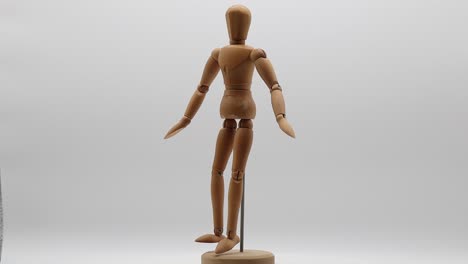 Wood-mannequin-over-white-background-rotating
