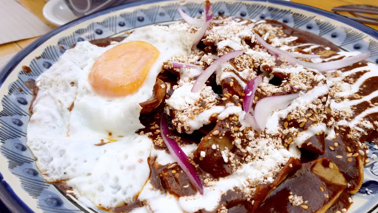 Hidangan tradisional dengan telur goreng dan saus di festival Cholula