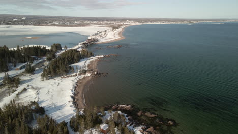 drone flight over the ocean in winter with snow in chandler, quebec, canada