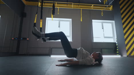 sporty woman doing trx exercises in the gym. women training with fitness straps in the gym. beautiful lady exercising her muscles sling or suspension straps.