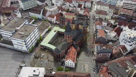 people and colorful houses around protestant gothic stiftskirche church at old city of kaiserslautern, germany