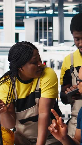 vertical video black team of manufacturing plant employees fixing technical issues or errors