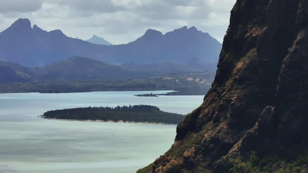 Sweeping coastal view reveals turquoise bay and dramatic peaks along the Mauritius shoreline