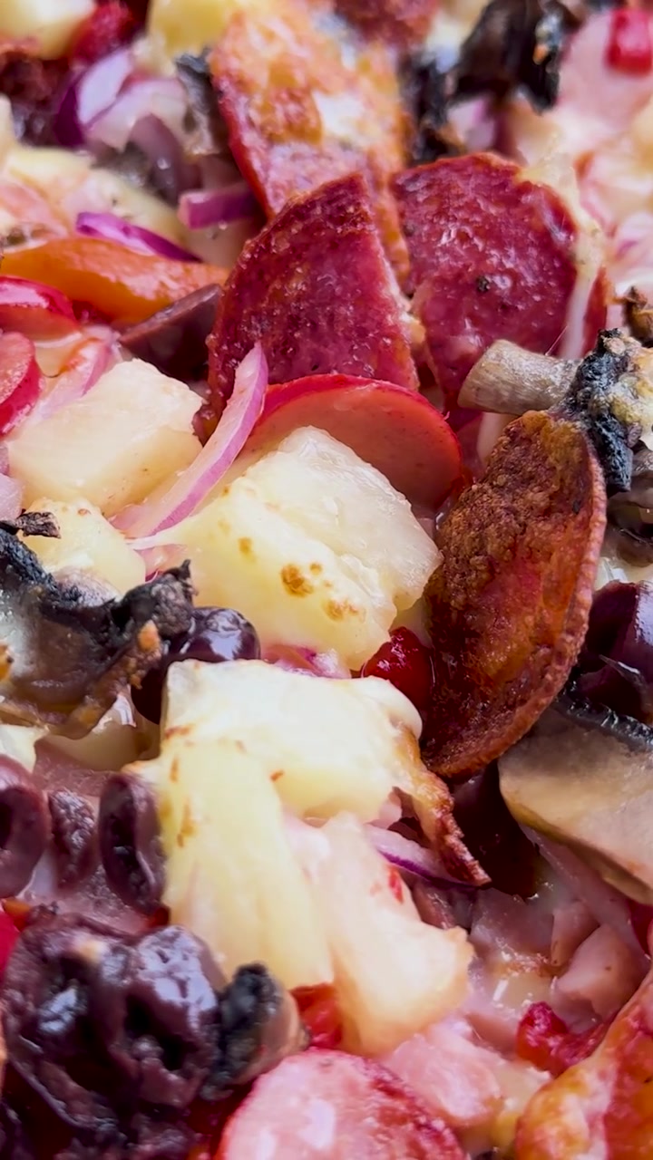Una pizza che gira, mostrando vari condimenti