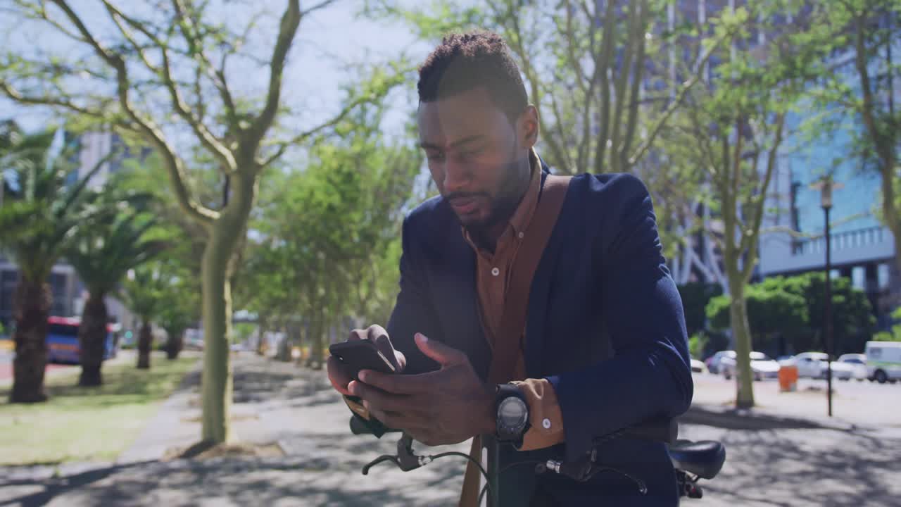 Man by bike tapping phone causing social badges clustering around him boosting followers smiling