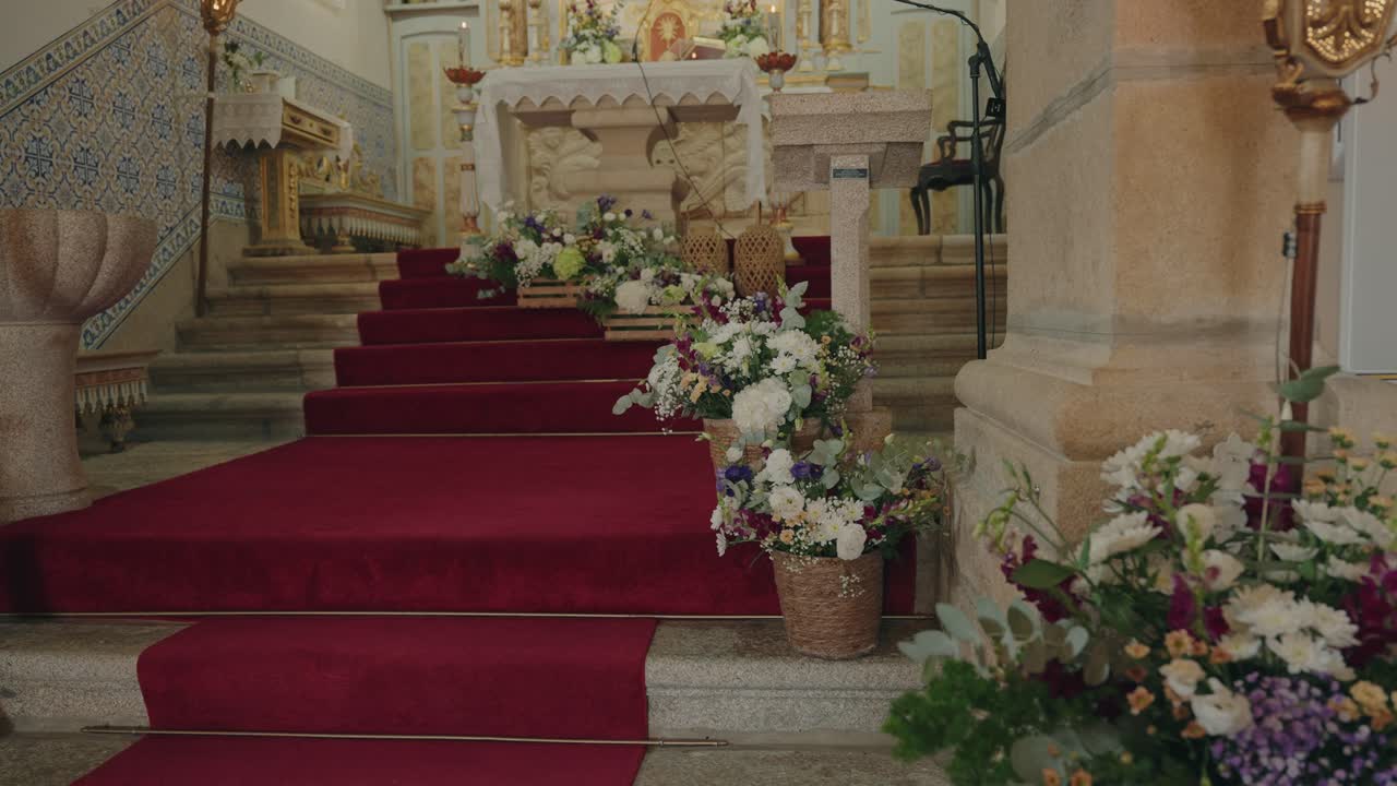 Sontuose composizioni floreali che adornano i gradini rossi che conducono a un altare sfarzoso