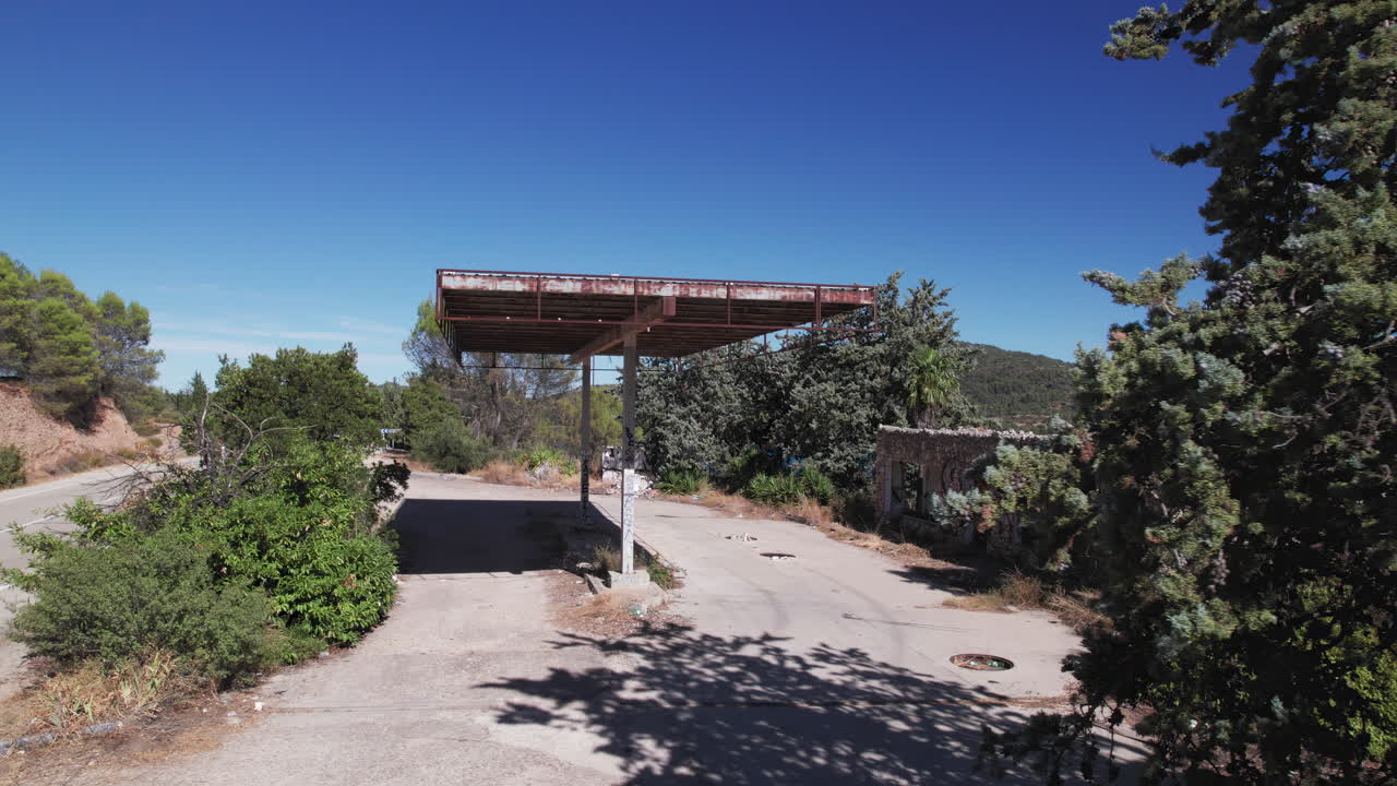 Panoramic shot of Abandoned gas station, moving sideways to reveal the Embalse de Entrepeñas reservoir, Spain