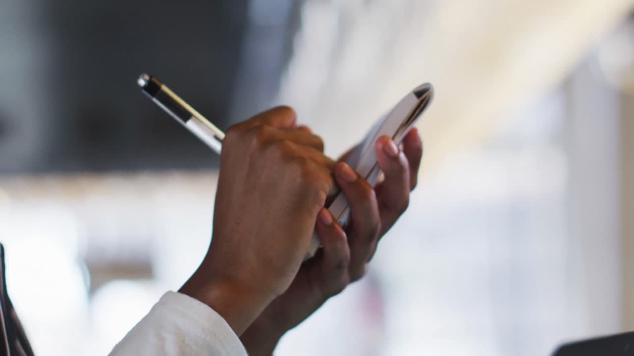 Mixed race man giving african american female cafe worker his smartwatch in order to pay