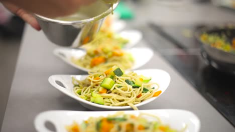 Professional-chef-demonstrating-process-of-serving-dish-on-plate-at-cooking-workshop