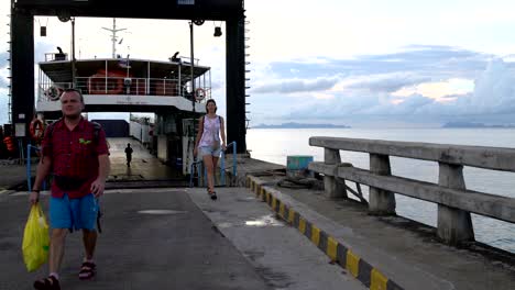 la mujer y el hombre dejan el ferry.