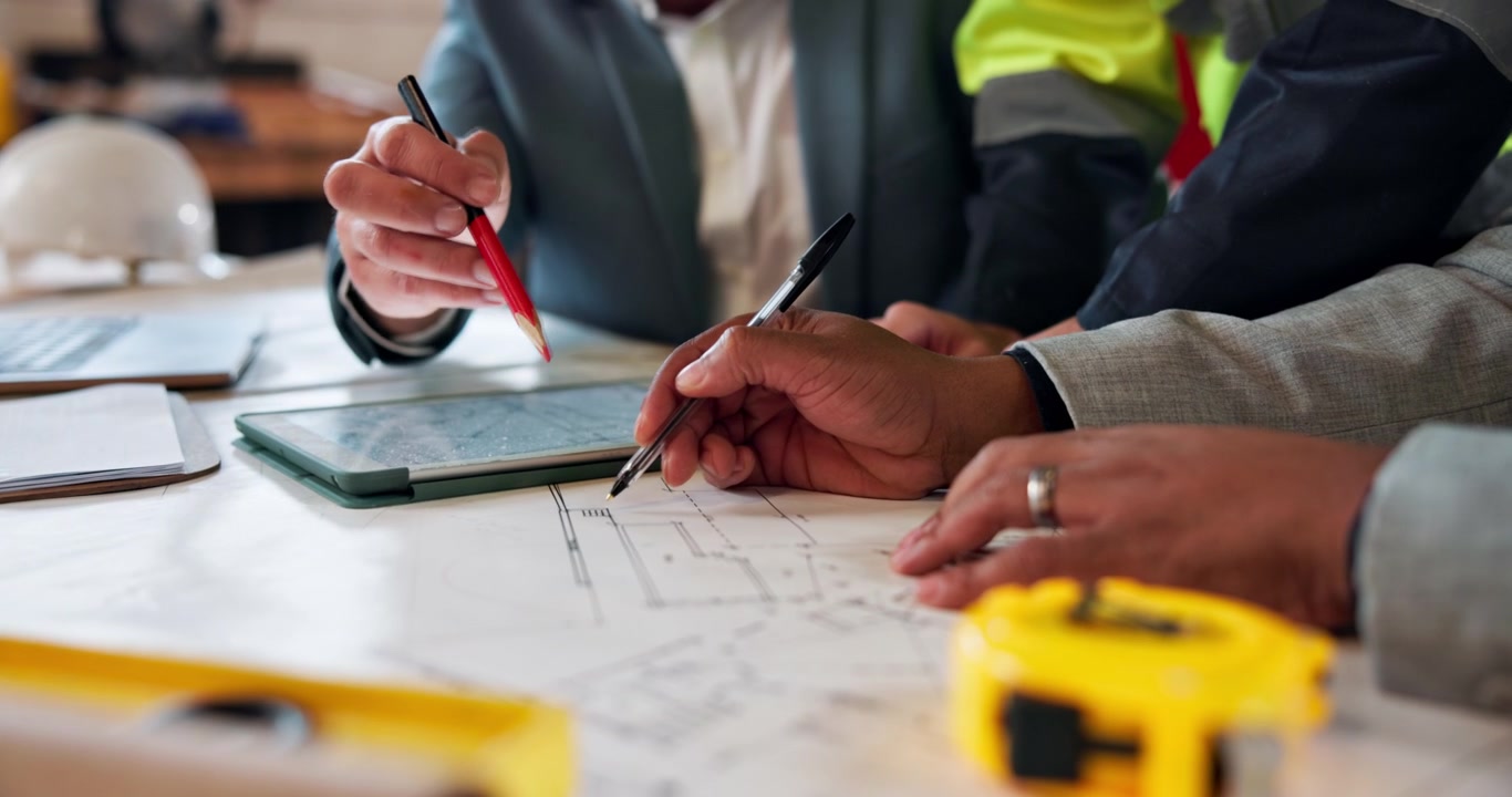 Architects and Engineers Reviewing Construction Blueprints in Office