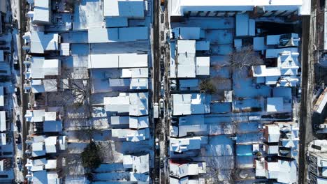 densely populated american neighborhood with snow covered roofs