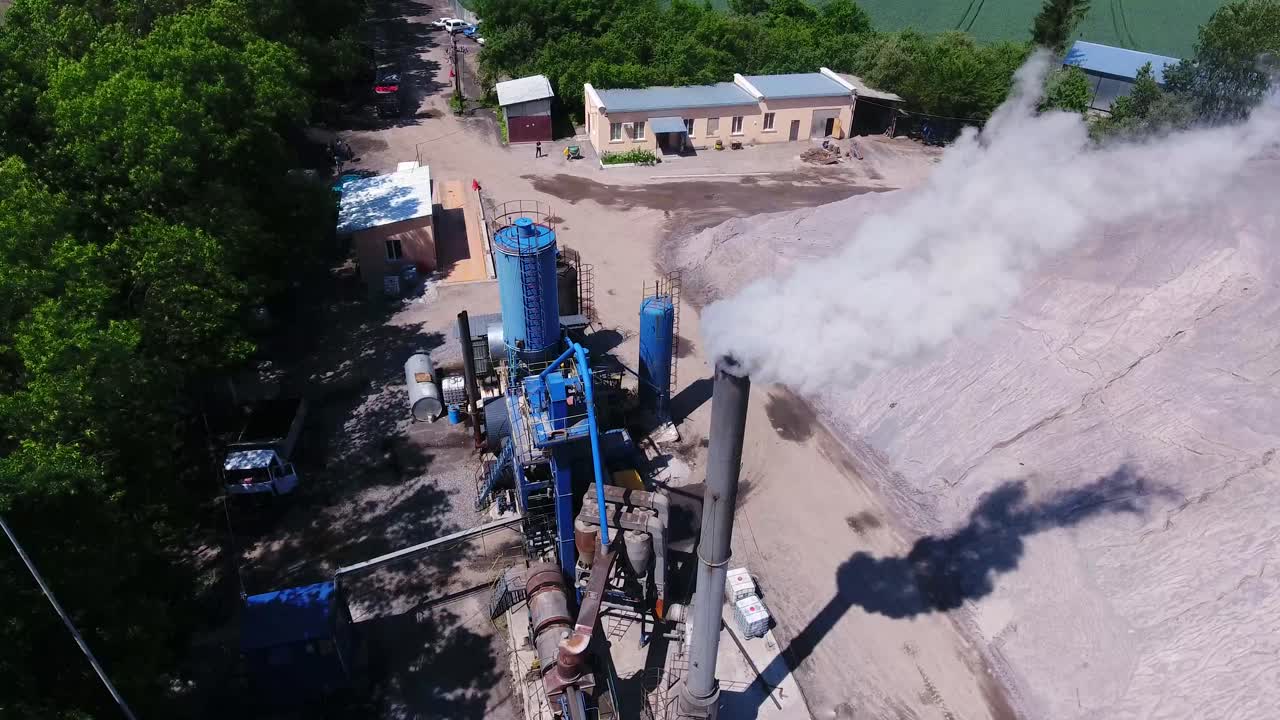 smoke from an asphalt pipe factory. aerial photography. large mound of rubble