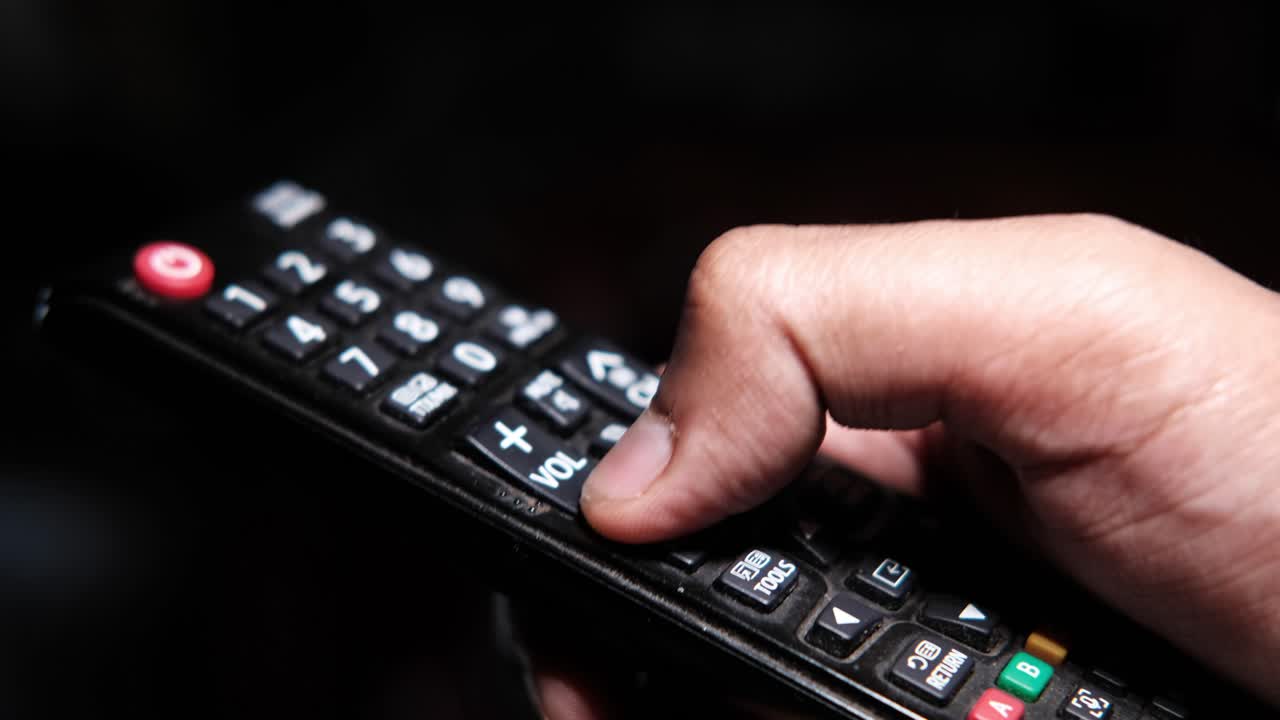 tv 리모컨을 들고 있는 손