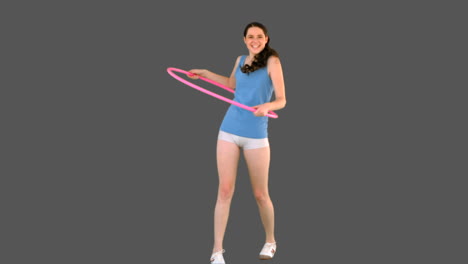 Young-model-in-sportswear-exercising-with-hula-hoop