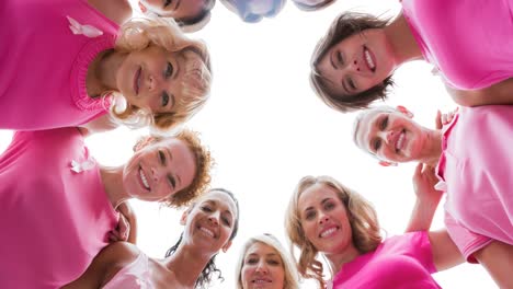 Portrait-of-diverse-group-of-smiling-women-outdoors-in-the-sun-from-below