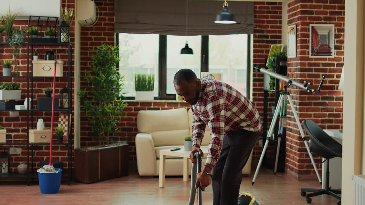 African american partner using vacuum to clean dust in living room