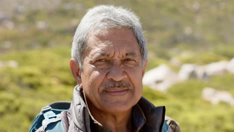 portrait of happy senior biracial man in mountains, in slow motion