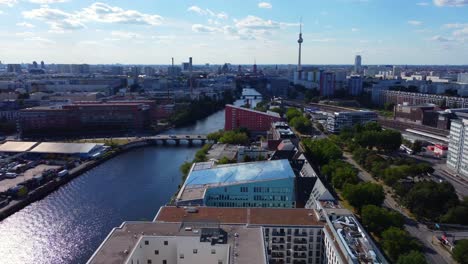 spree, tv tower, s-bahn station train arrives smooth aerial view flight pan from left to right drone footage of berlin friedrichshain sunny summer day 2022 cinematic view from above by philipp marnitz