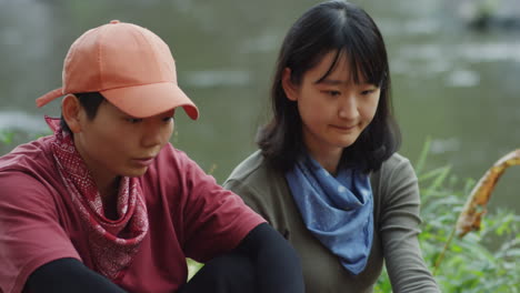 lesbian couple talking by bonfire at campsite