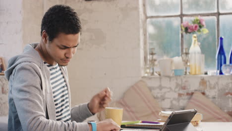 Young-student-using-smart-watch-at-home-in--morning-drinking-coffee