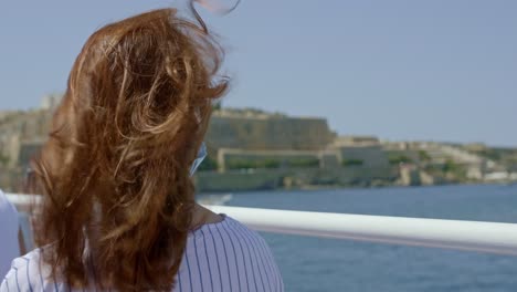 young woman in face mask enjoys a sightseeing trip around the grand harbor valletta malta - copy space