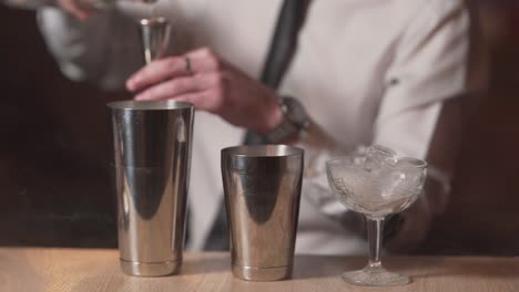 professional bartender pouring vodka in a cocktail shaker