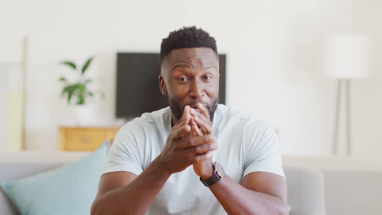 retrato de un feliz hombre afroamericano haciendo una videollamada en la sala de estar