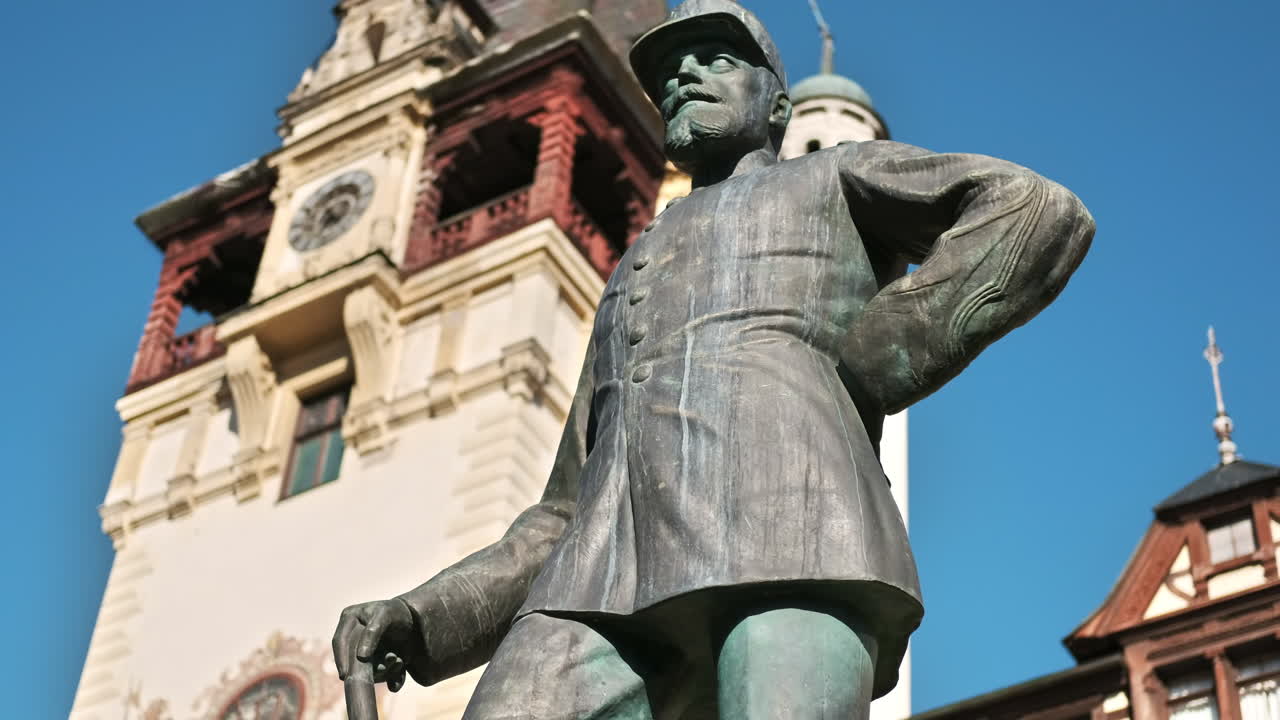 King Carol statue at The Peles Castle in Romania. Castle on the background