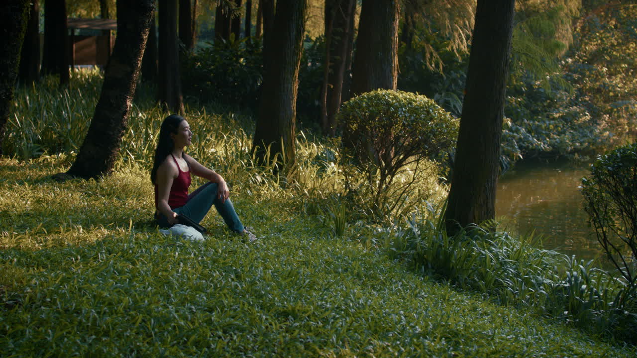 Woman Relaxing in a Park by a Pond