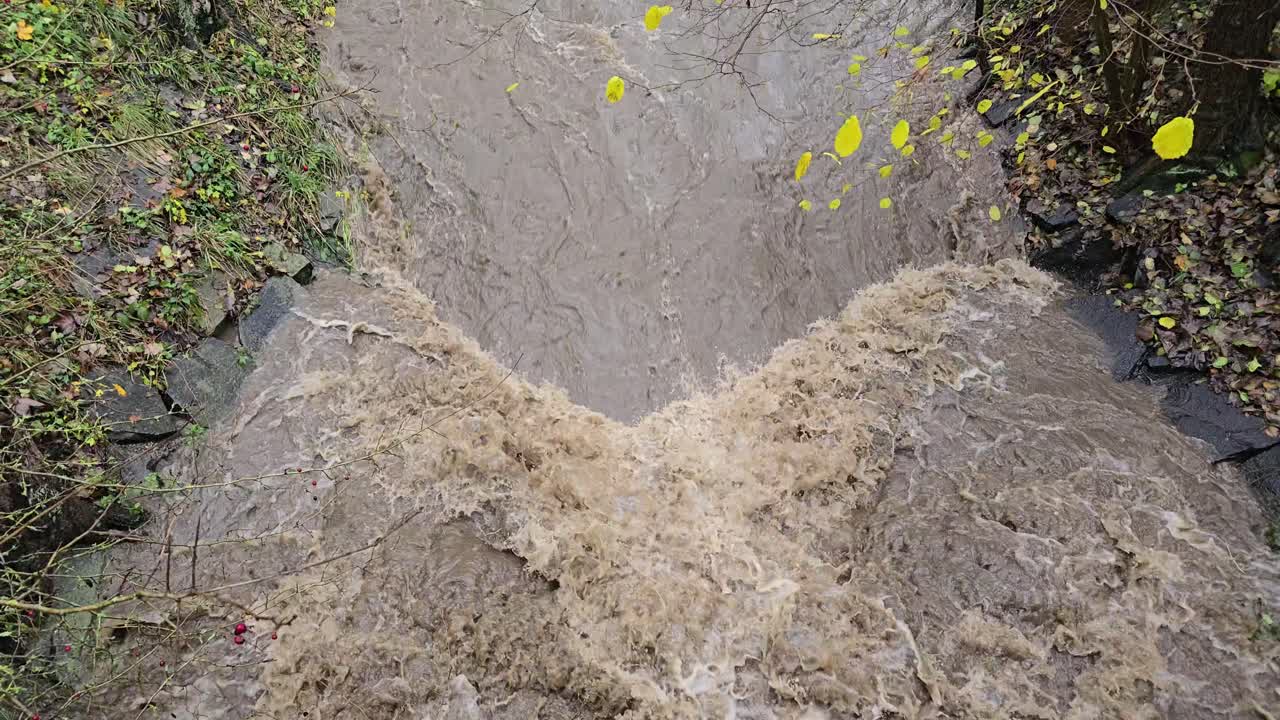 River flooding after heavy rain with strong waterfall and high flood risk