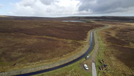drone video footage of a reservoir and overflow system in the saddleworth moors in west yorkshire uk, showing work vehicles and plant machinery