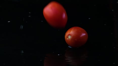 cherry tomatoes falling into a black puddle