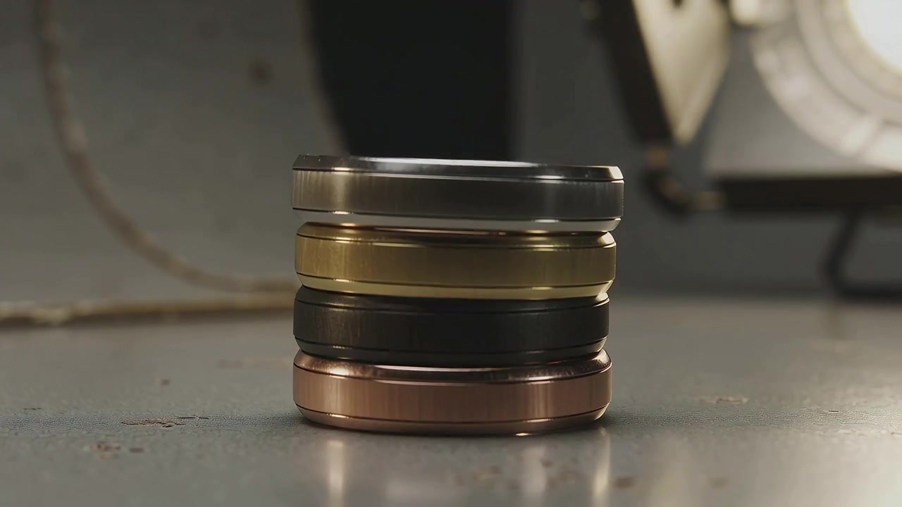 Rolling metal ring causing rings tumbling on metal table, stacking into five rings under spotlight