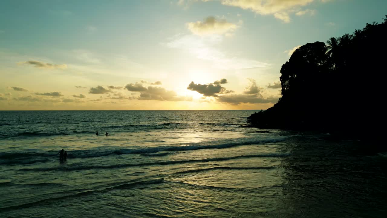 Riprese aeree cinematiche 4K della natura di un drone che vola sulla splendida spiaggia di Surin a Phuket, Thailandia, durante il tramonto.