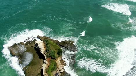 scenic rock at popular klayar beach in east java, indonesia, aerial reveal shot