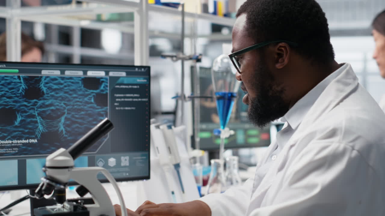 Vertical video Microbiologist in lab inspects slide using optical device, analyzing on PC