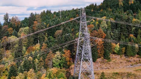 Toma-Aérea-En-órbita-Alrededor-De-Un-Alto-Pilón-De-Línea-Eléctrica-Durante-La-Temporada-De-Otoño-En-4k