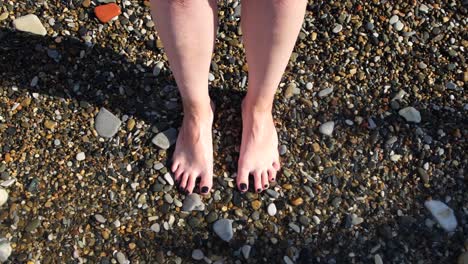 woman's feet in shallow water on a beach